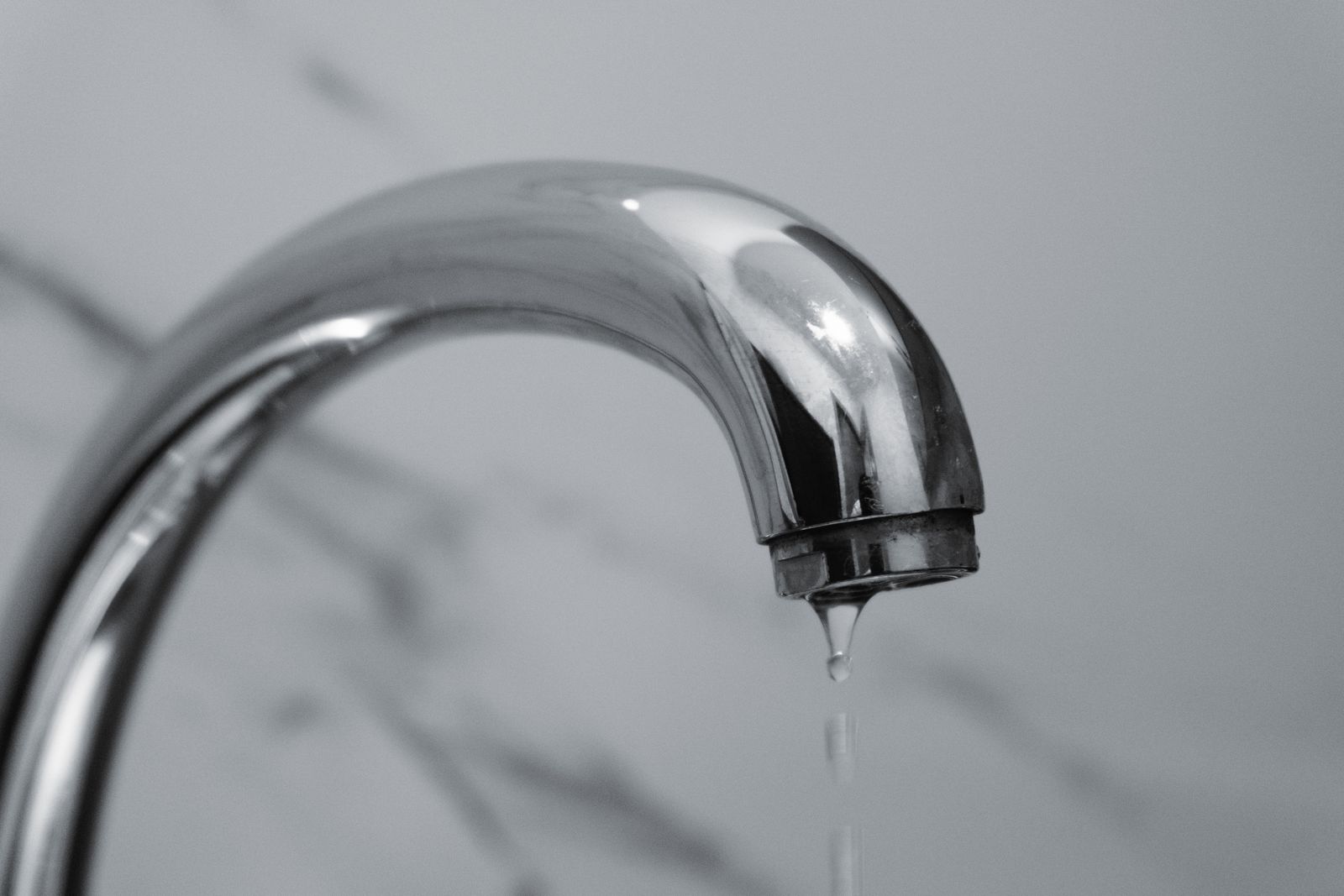 Water dripping from a chrome bathroom faucet